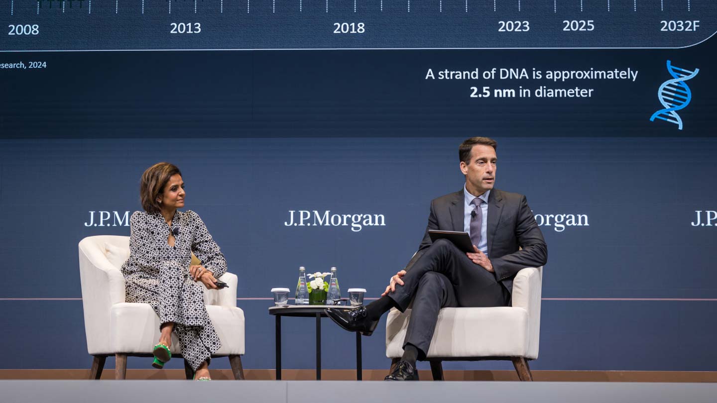 Man and woman seated on stage
