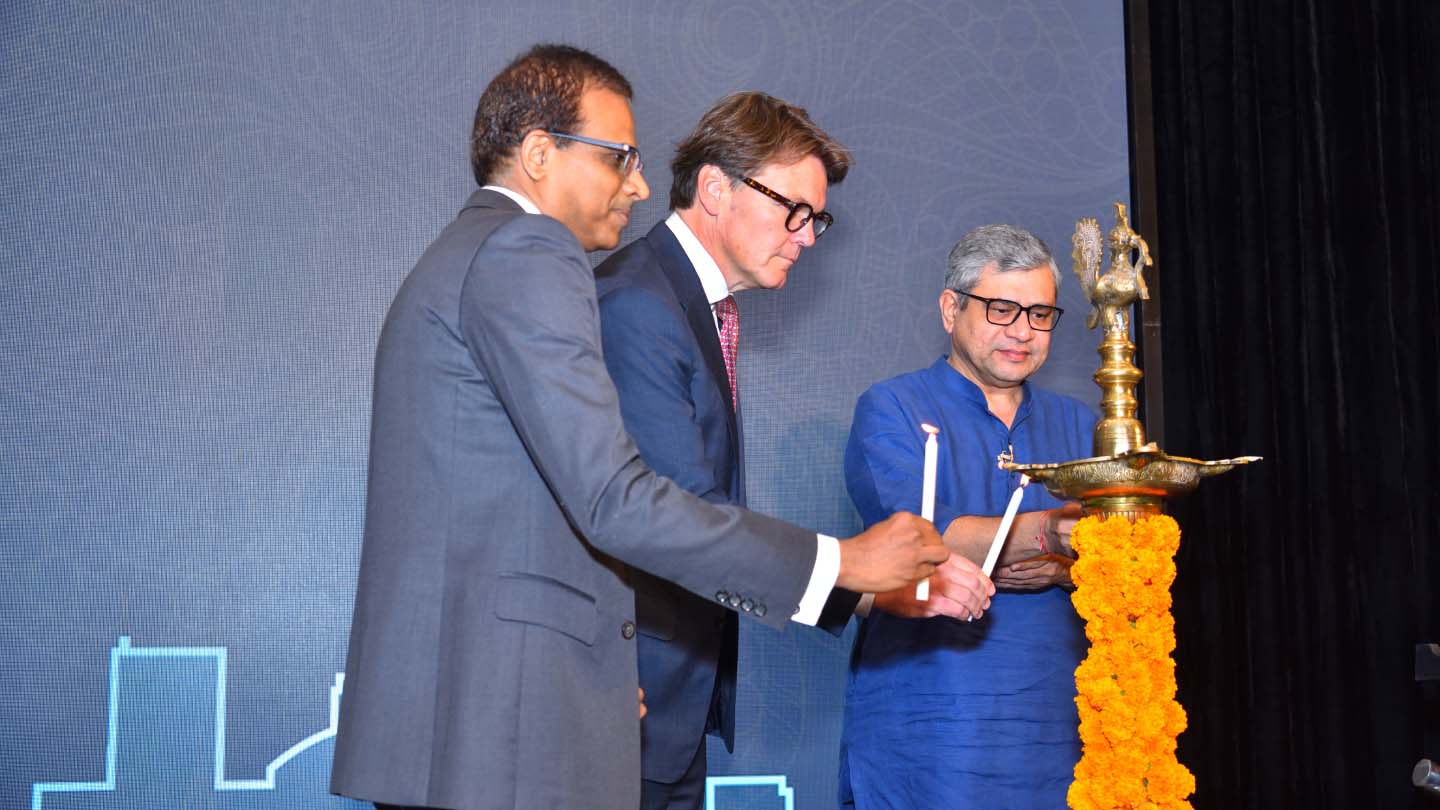Three men lighting a diya lamp