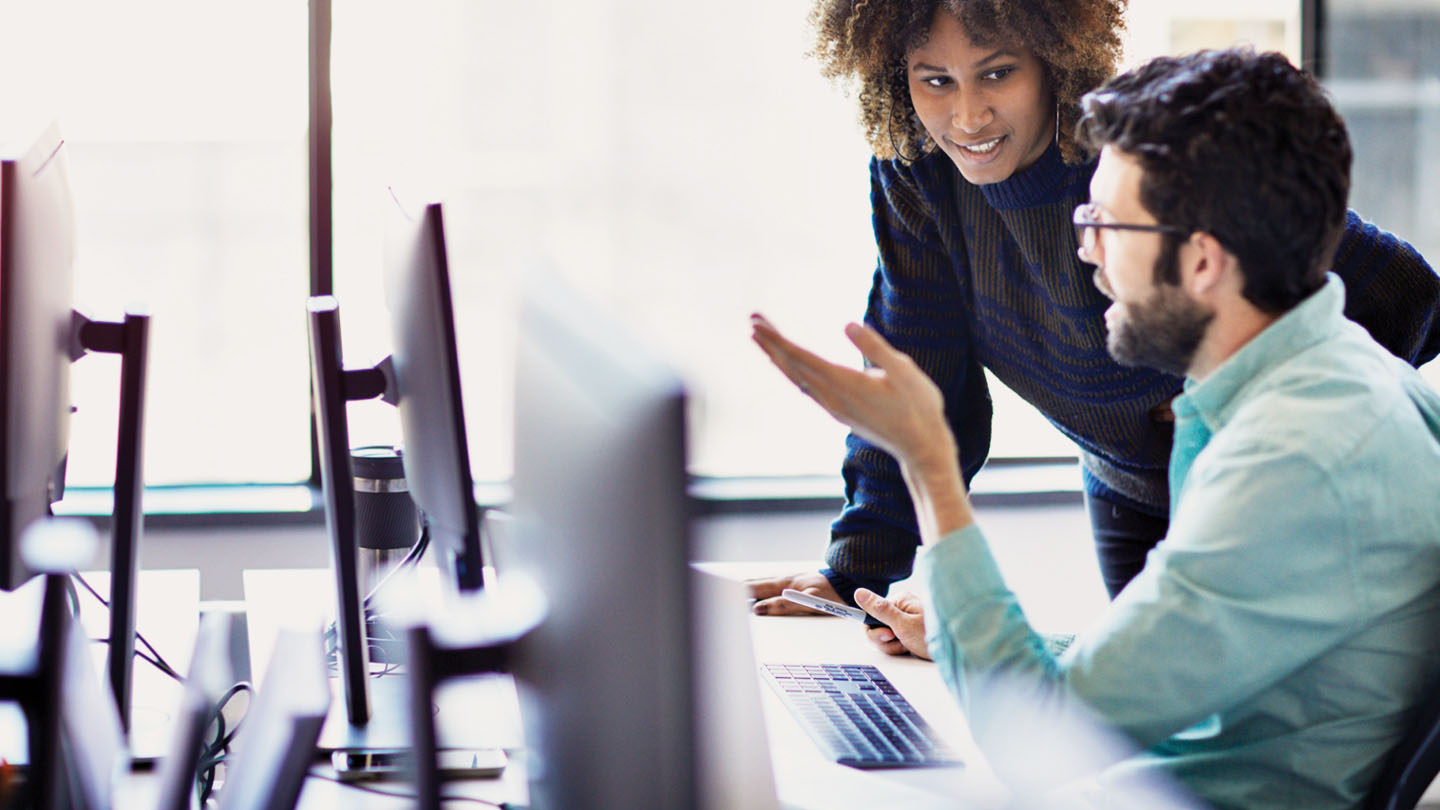 Two professionals consulting by a computer