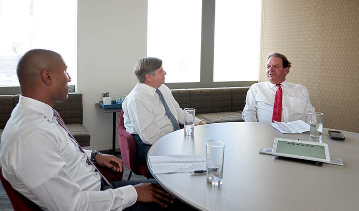 Three men at round table discussion