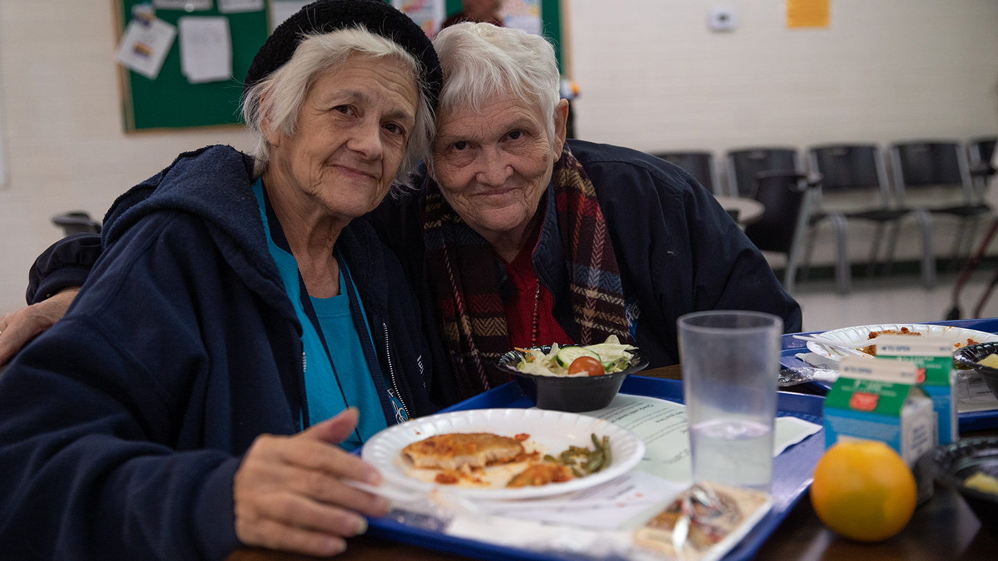 Two women eating at Three Square Food Bank