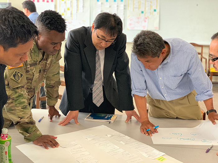 Gooden looks intently at plans with three other men from the U.S. Army Corps of Engineers.