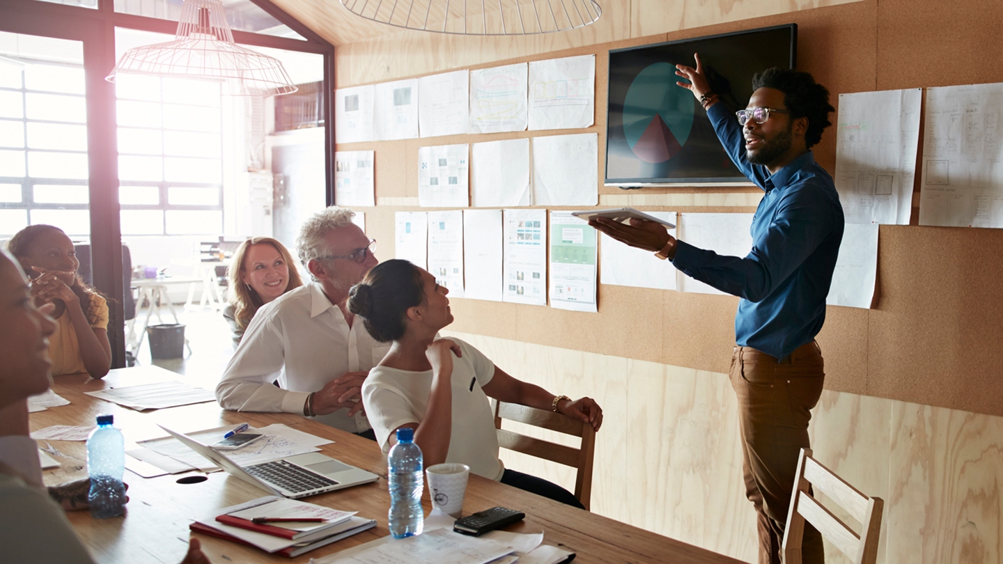 Person giving a presentation and others watching the presentation