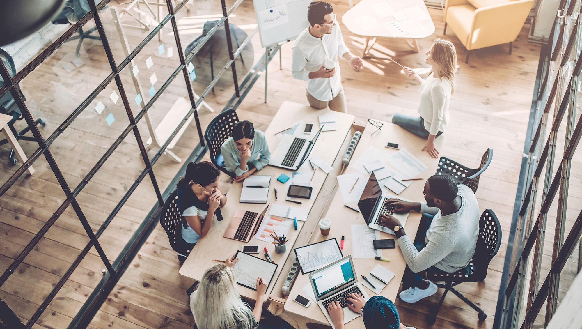 Aerial view of employees working around a table 