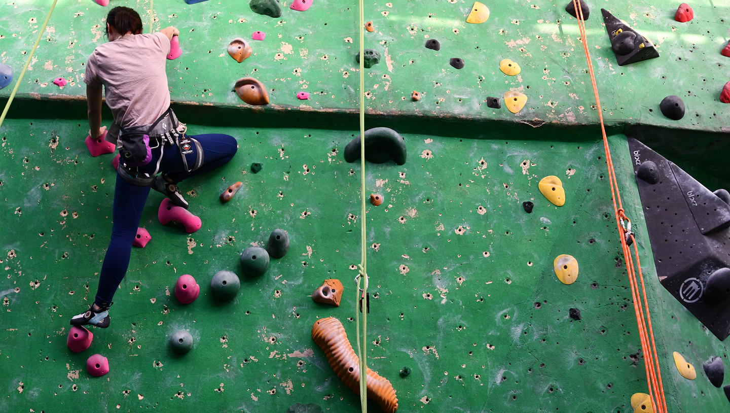 Person climbing an indoor rock climbing wall 