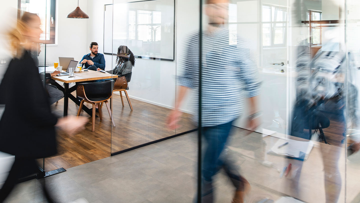 View of a corporate office hallway full of employees