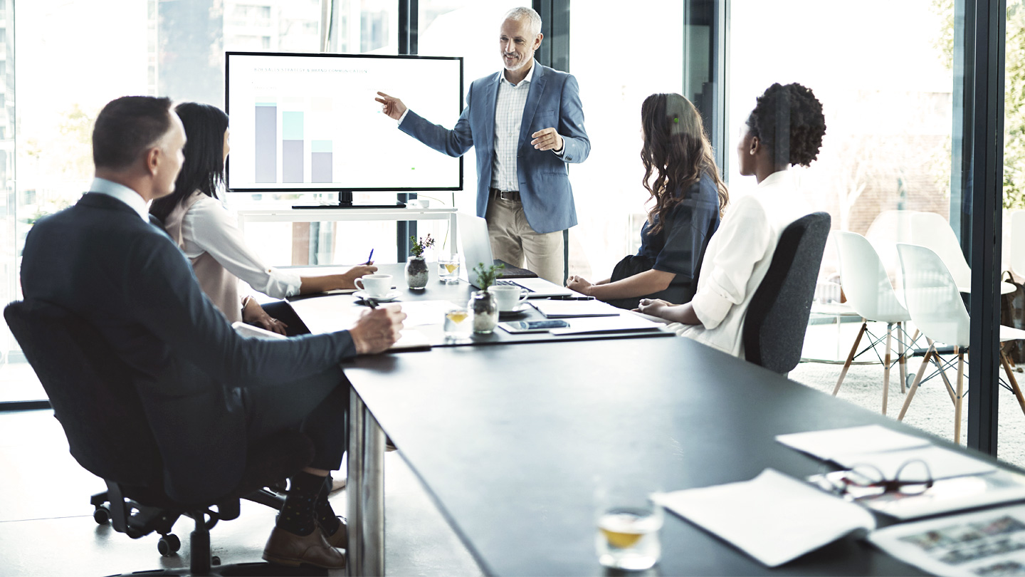 Man standing and leading a boardroom meeting