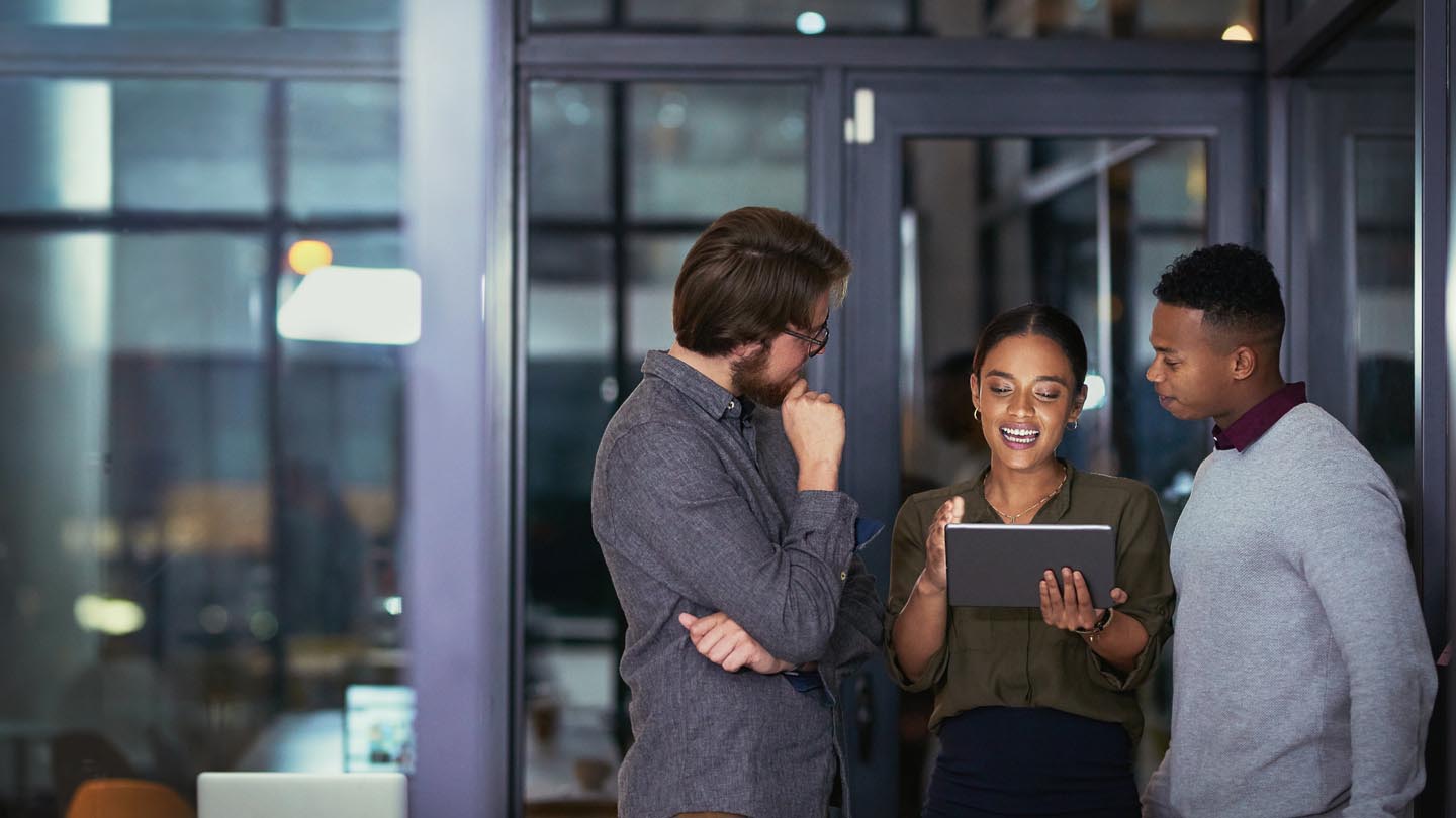 Three people consulting with laptop