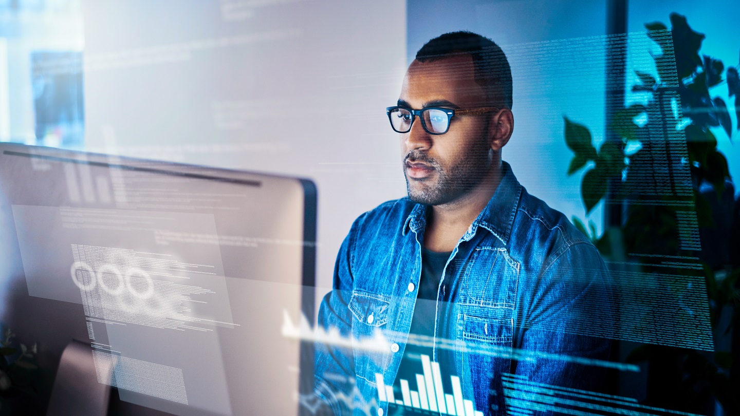 Shot of a programmer working on a computer code at night