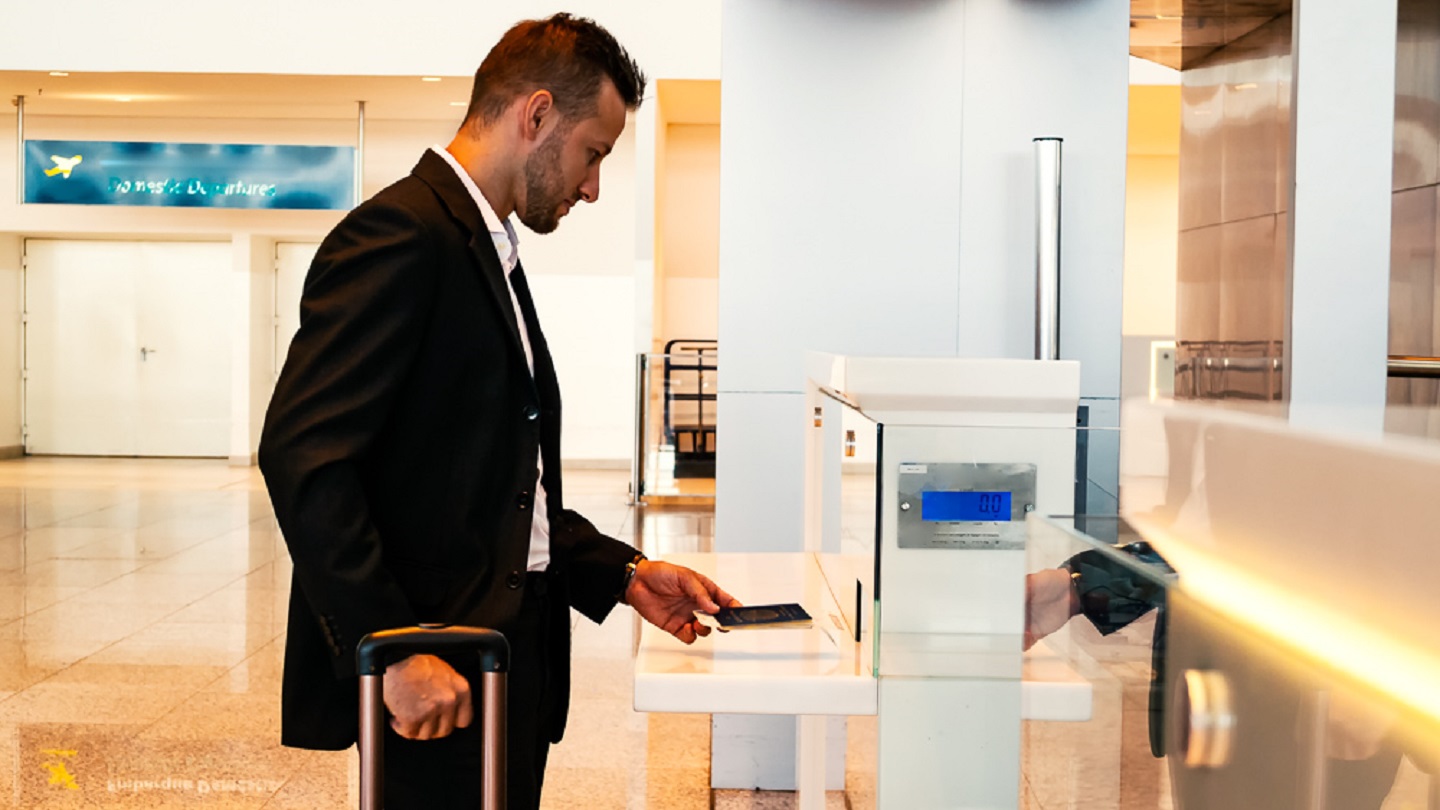 Photo of a young businessman at an airport making check in.