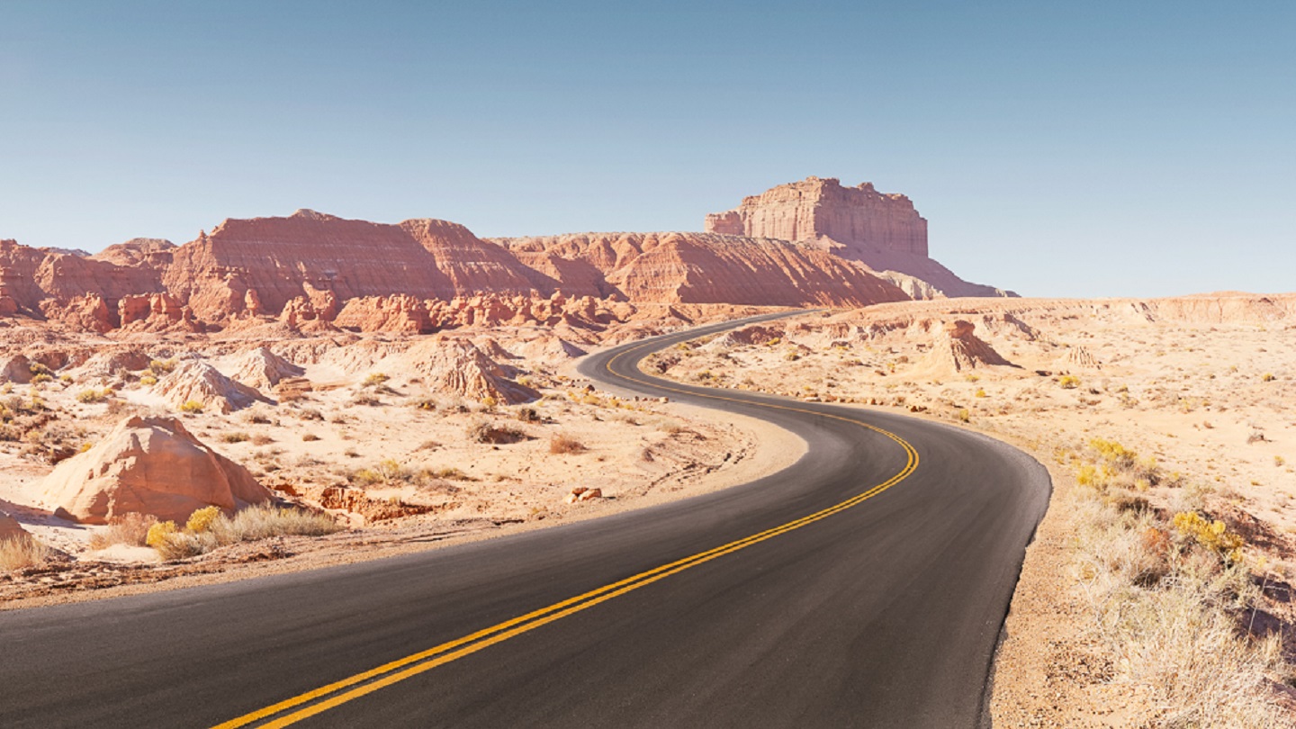 Winding empty road through arid desert landscape panoramic