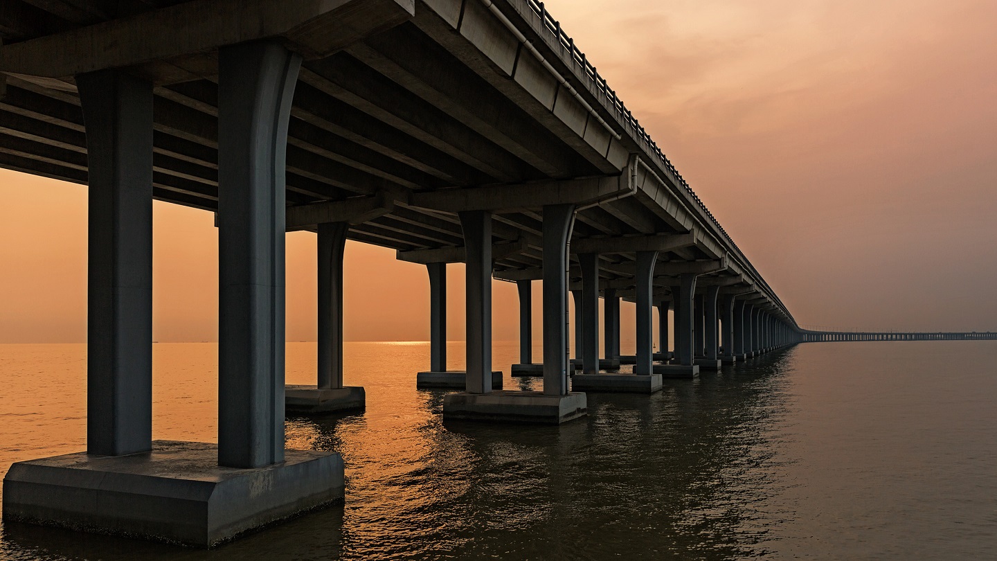 highway bridge across the sea in sunset