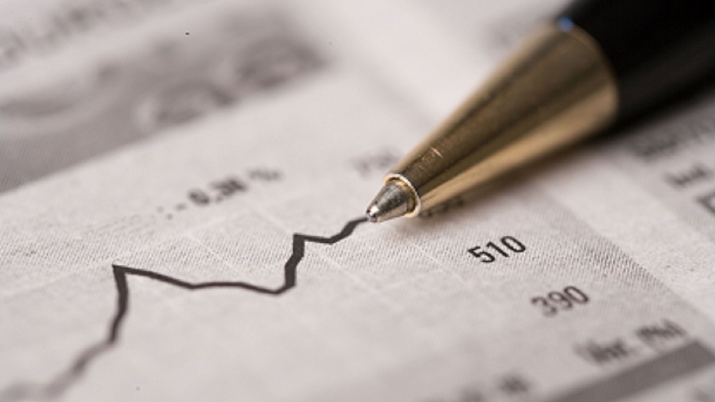 Chart of stock bonds growth with a black pen over the newspaper.