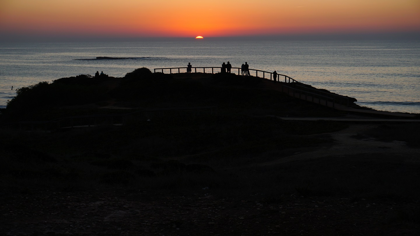 people gathering for sunset celebration at the coast