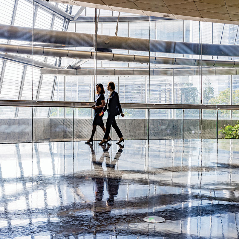 Two people walking in a corporate environment