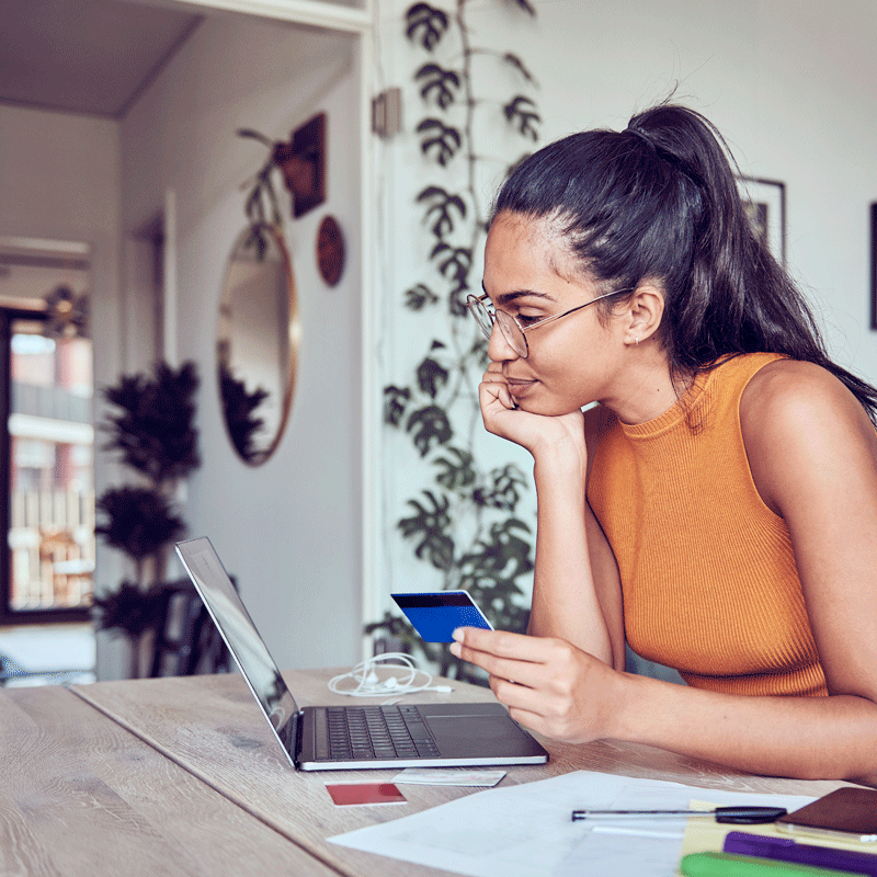 Woman wearing glasses holding credit card