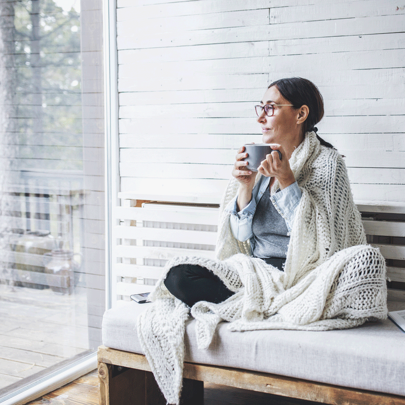 Woman sitting holding a cup of coffee