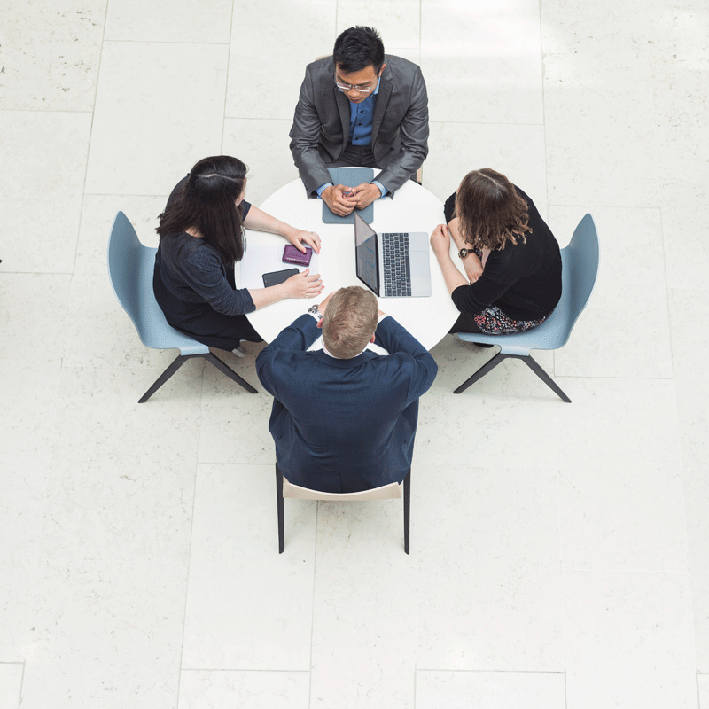 4 people talking while sitting by a table