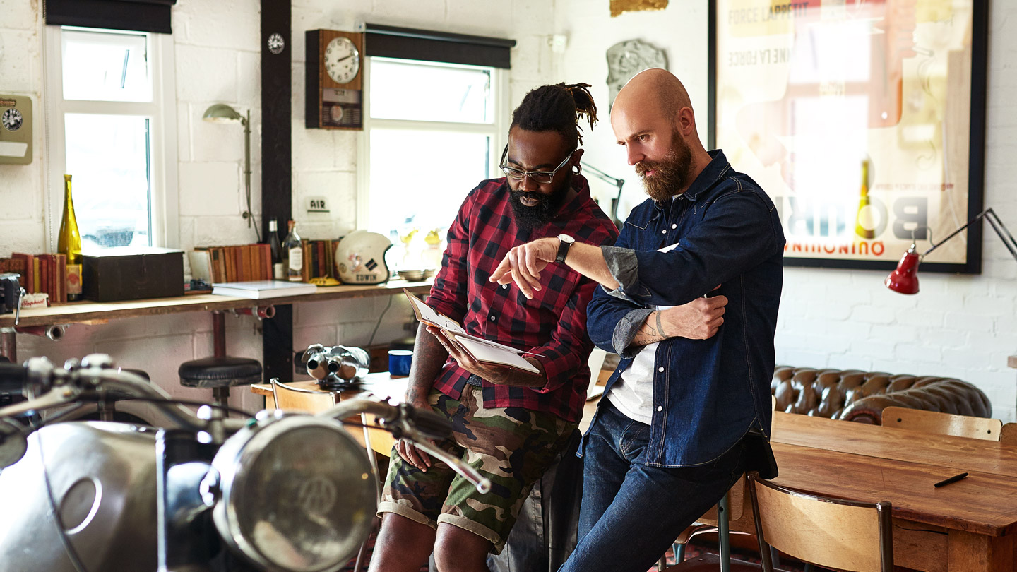 Two people consulting over folder