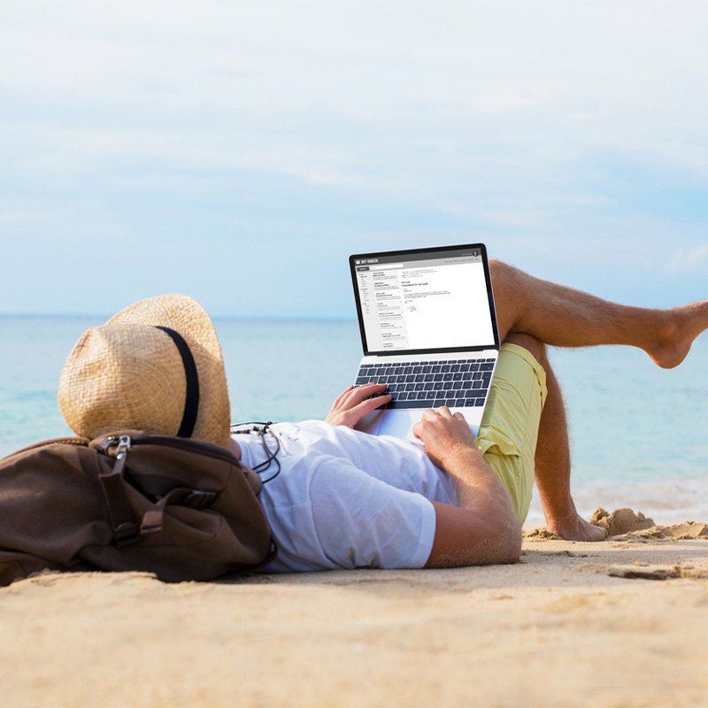 Man lying on beach with computer