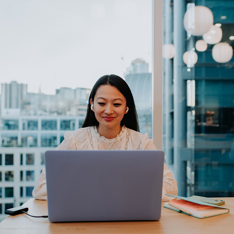 woman using laptop near window