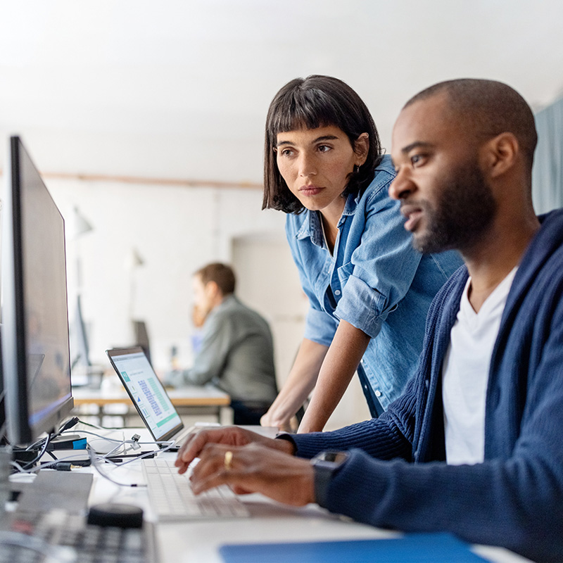 man and woman looking at computer screen
