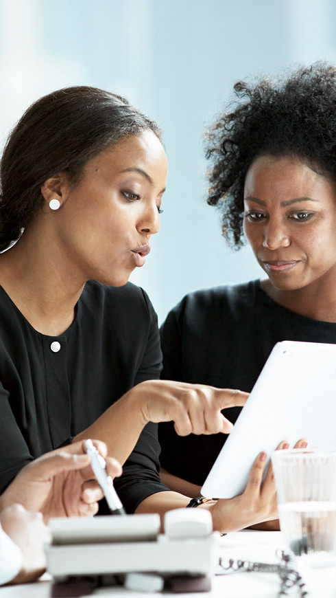 Two women looking at a tablet together