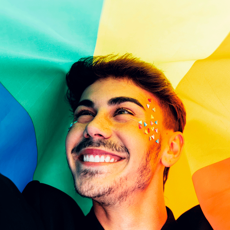 Man smiling against rainbow background