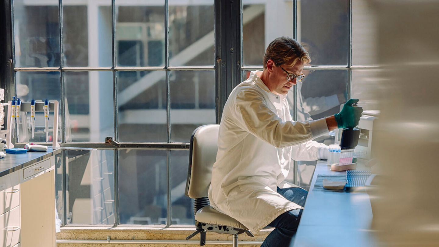 Man sitting at desk with lab equipment