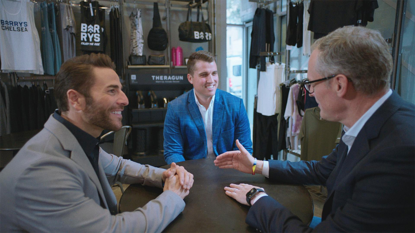 John Simmons, Head of Middle Market Banking and Specialized Industries at JPMorgan Chase, Joey Gonzalez, Global CEO at Barry's and Jonathan “JJ” Gantt, President and Chief Financial Officer at Barry's talking around a conference table together