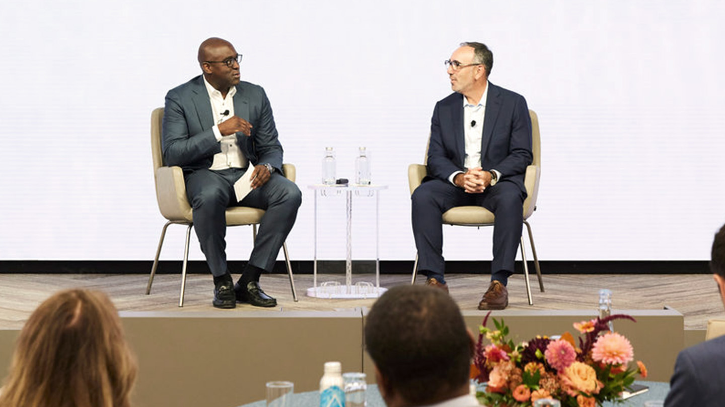 2 people sitting across each other at conference