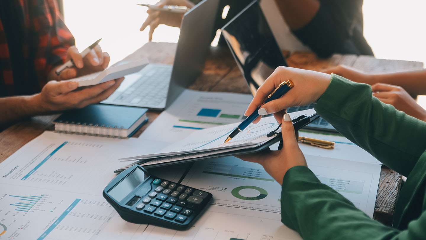 3 people reviewing documents with data