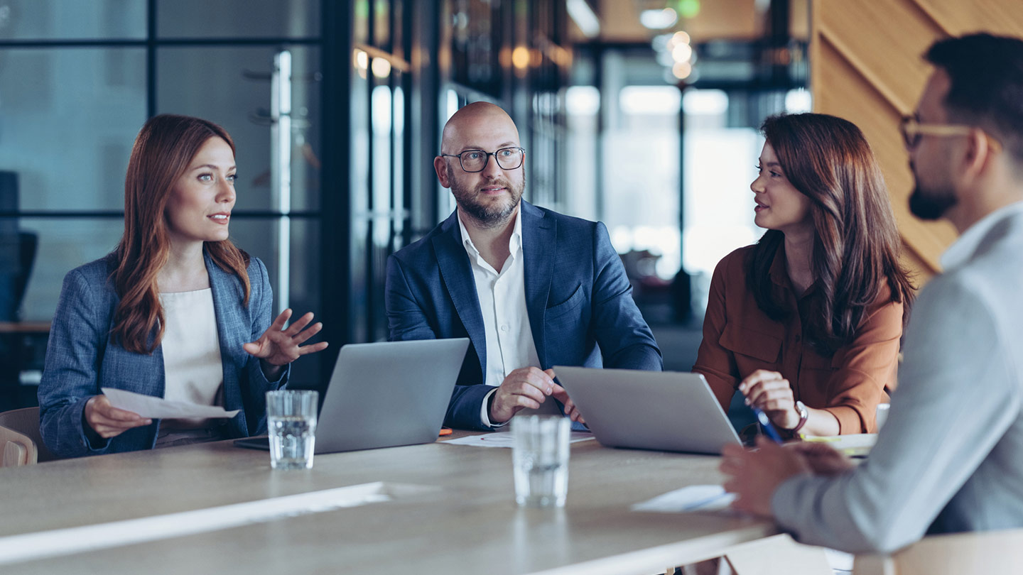 4 people in a meeting by a table