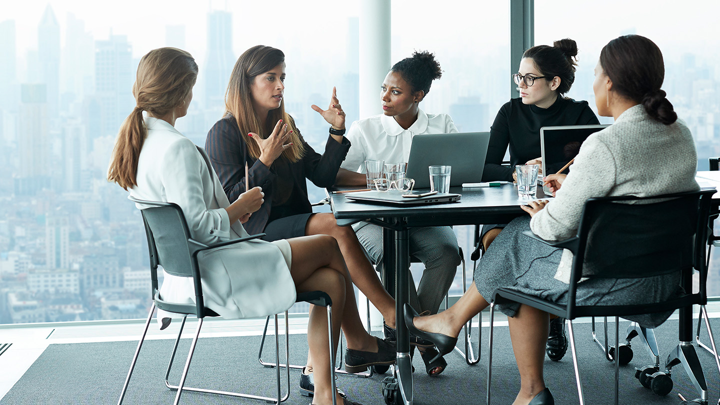 Group of women at a conference table talking