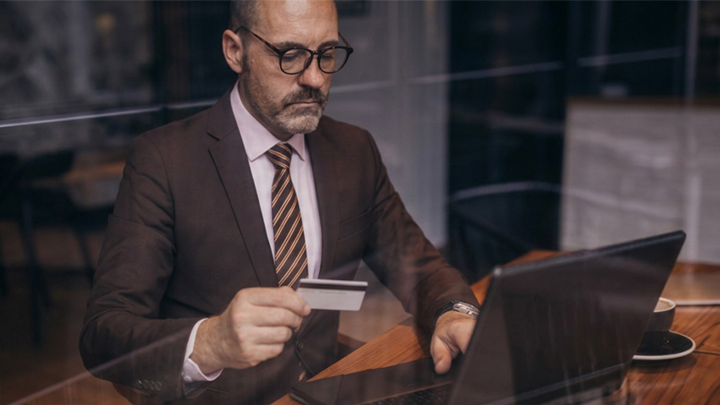 man using credit card on laptop