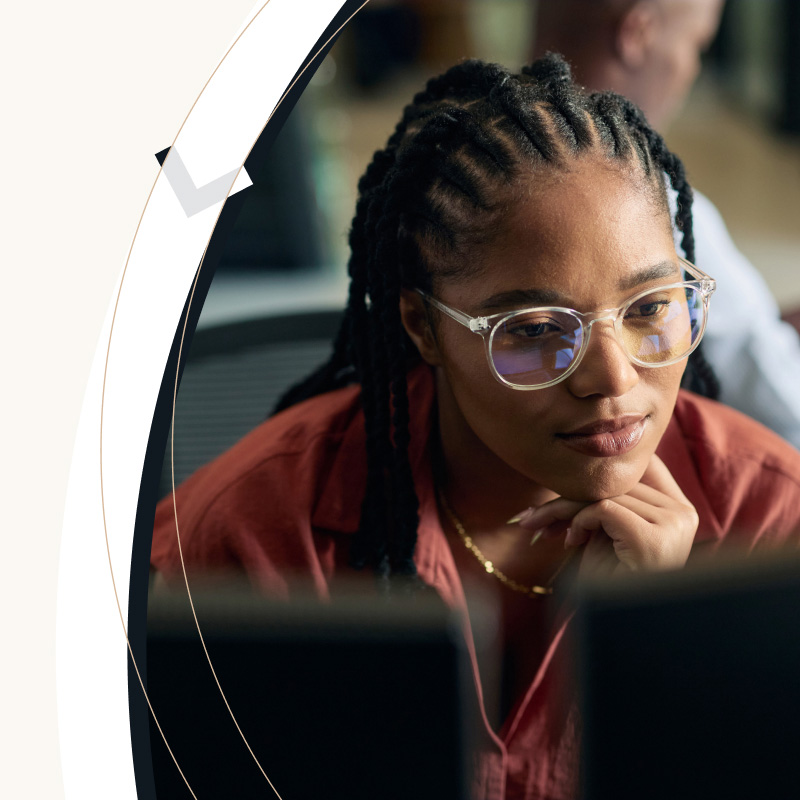 a woman looking at 2 screens