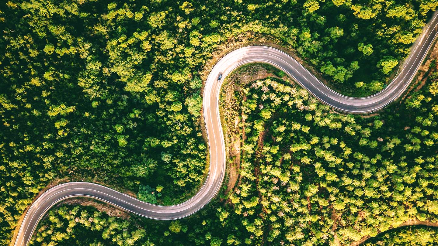 Aerial view of car driving on winding road 