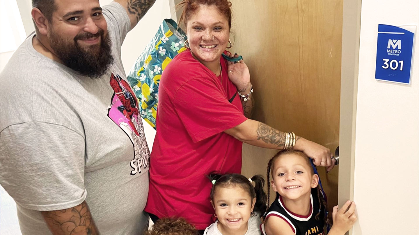 Couple and two children standing in apartment doorway