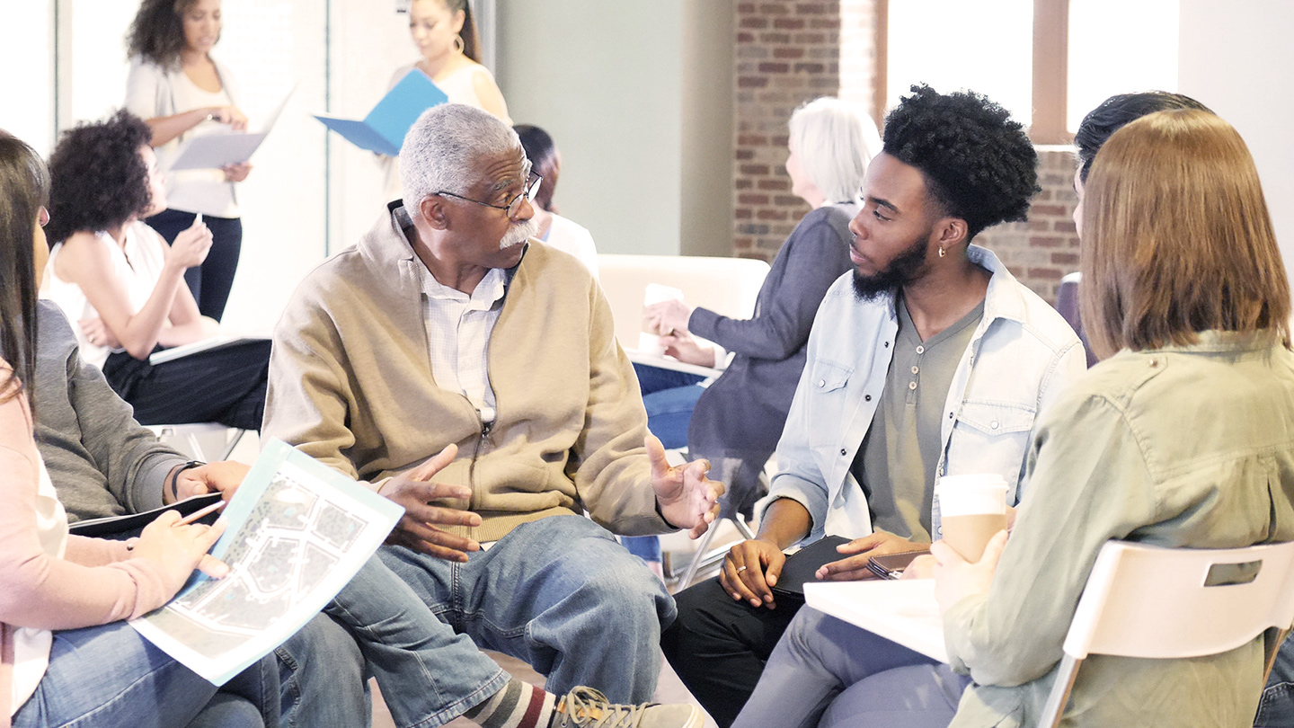 Two men speaking in seated group