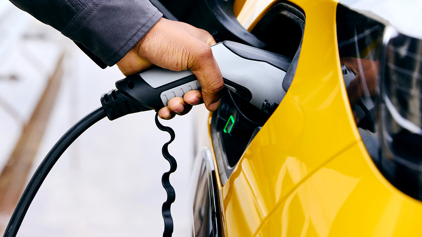 A man charges his electric vehicle