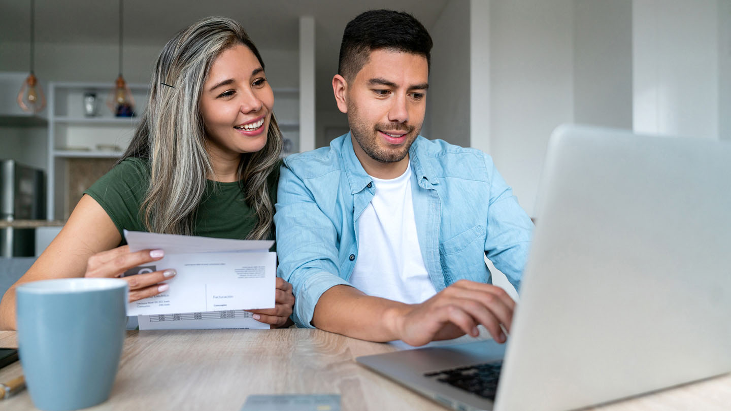 A couple works on their laptop inside their apartment.