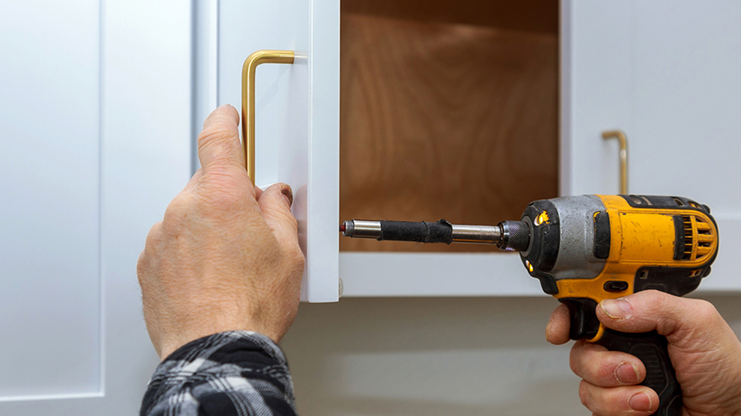 Installing new handles in a kitchen cabinet