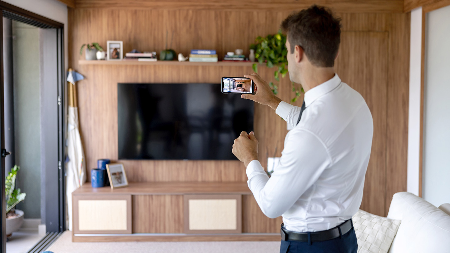 A man takes a photo with his phone of a rental unit