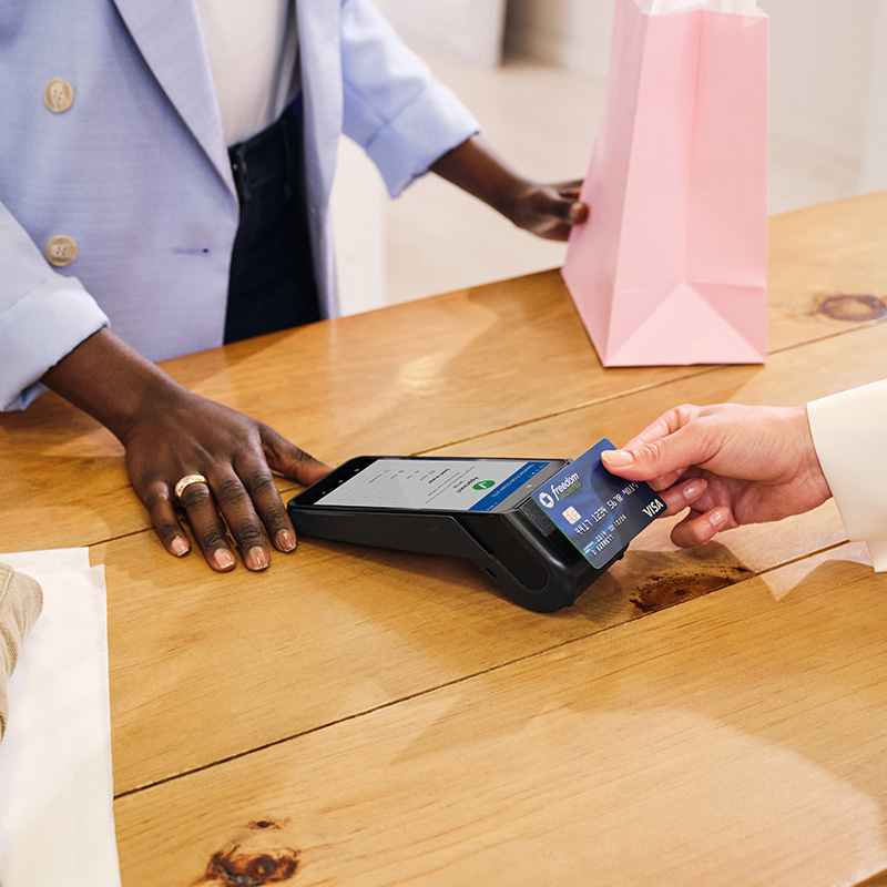 person swiping credit card on payment machine