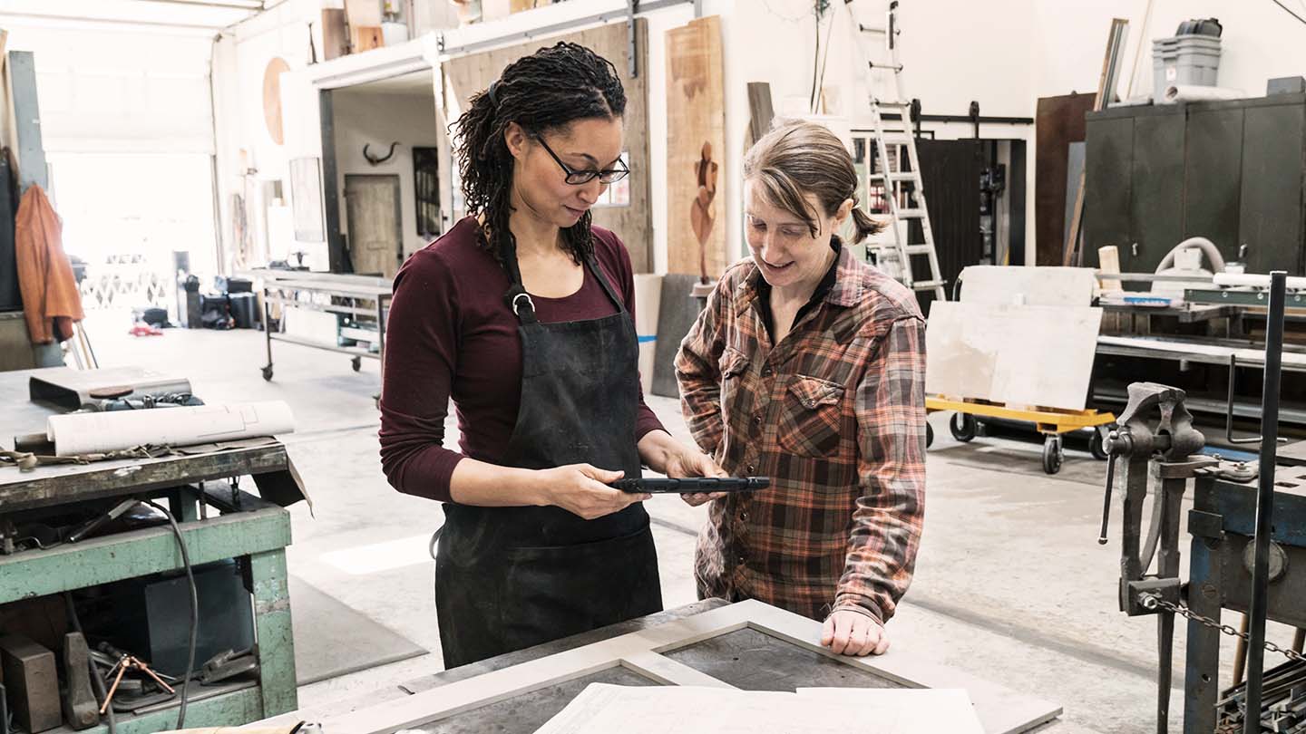 Two people looking at a tablet in an industrial facility