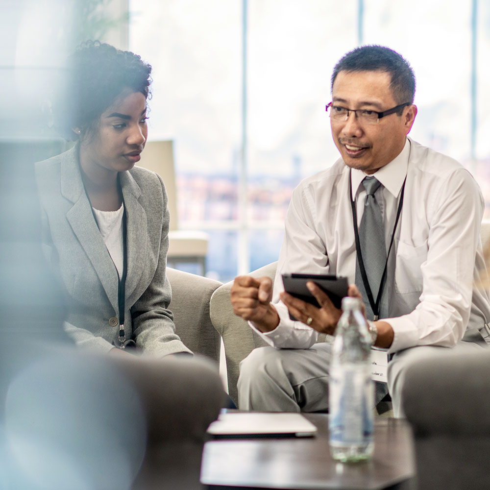 Two individuals consulting with a tablet