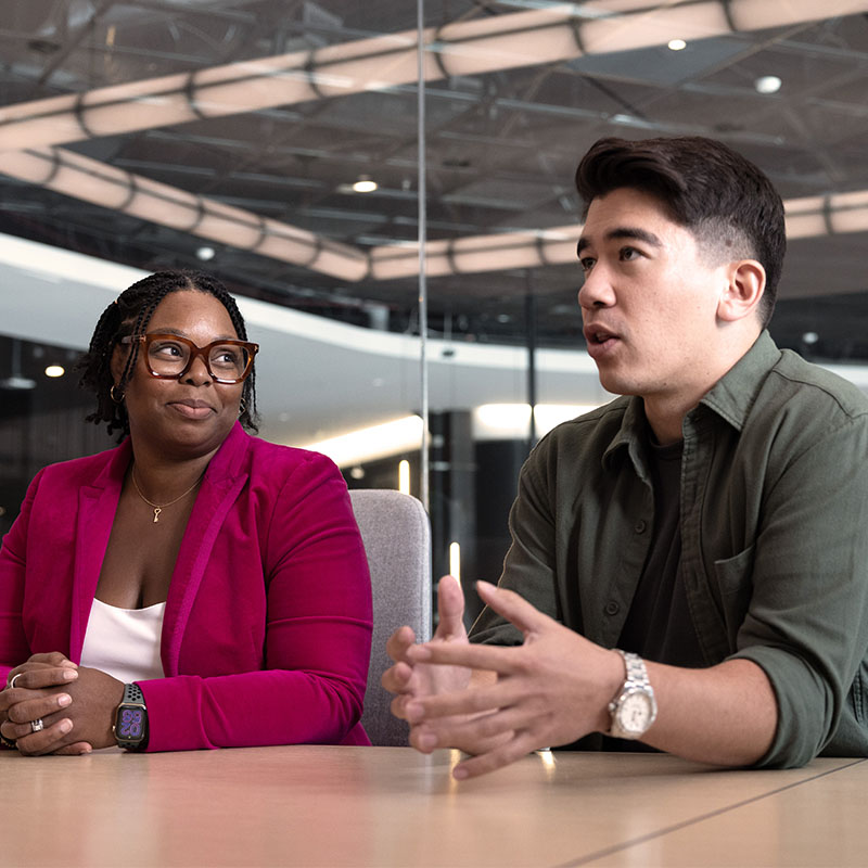 2 people in a meeting room talking