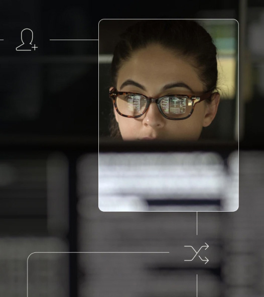 Close-up of a person wearing glasses focused on a computer screen, with faint interface-style overlay lines and icons.