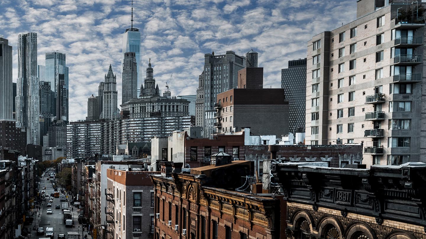 Magnificent scenery of the cloudy sky, the Lower Manhattan with its skyscrapers and the Chinatown captured from the Manhattan Bridge during one of the many visits of beautiful New York City.