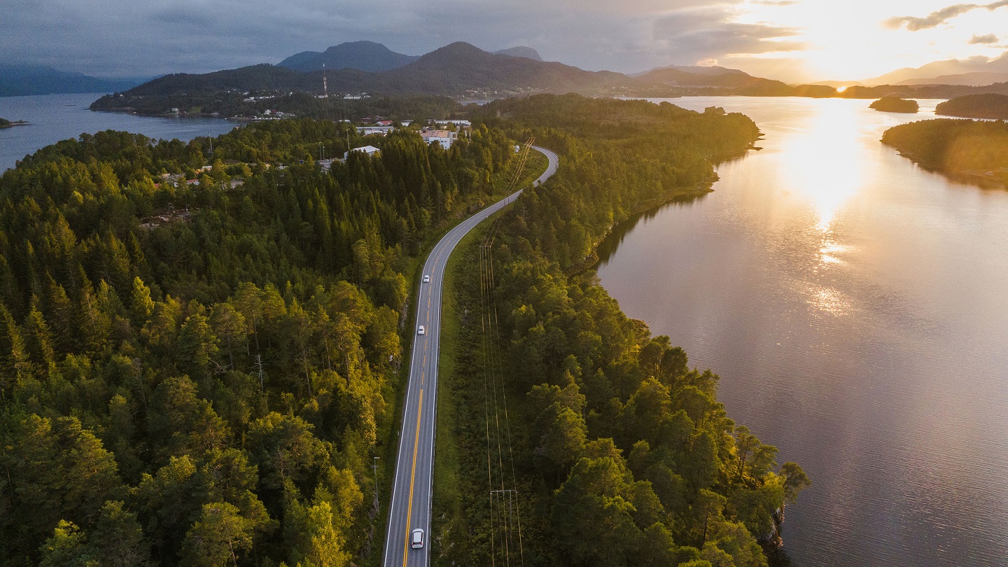 Scenic aerial view of car on the road near the   lake in Norway at sunset